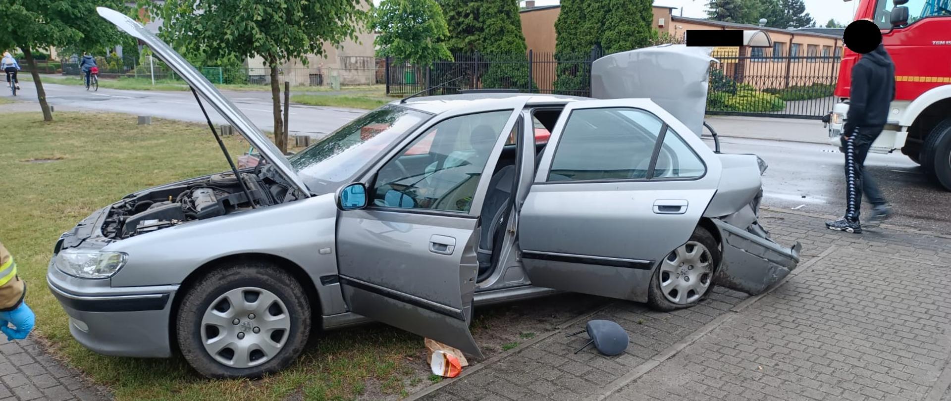 Widać uszkodzony samochód od strony kierowcy