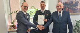 Zdjęcie przedstawia Komendanta Powiatowego PSP w Zgierzu, Starostę Zgierskiego oraz Burmistrza Strykowa z podpisanym porozumieniem dotyczącym przekazania działki pod budowę nowej strażnicy dla Jednostki Ratowniczo - Gaśniczej Państwowej Straży Pożarnej w Strykowie.