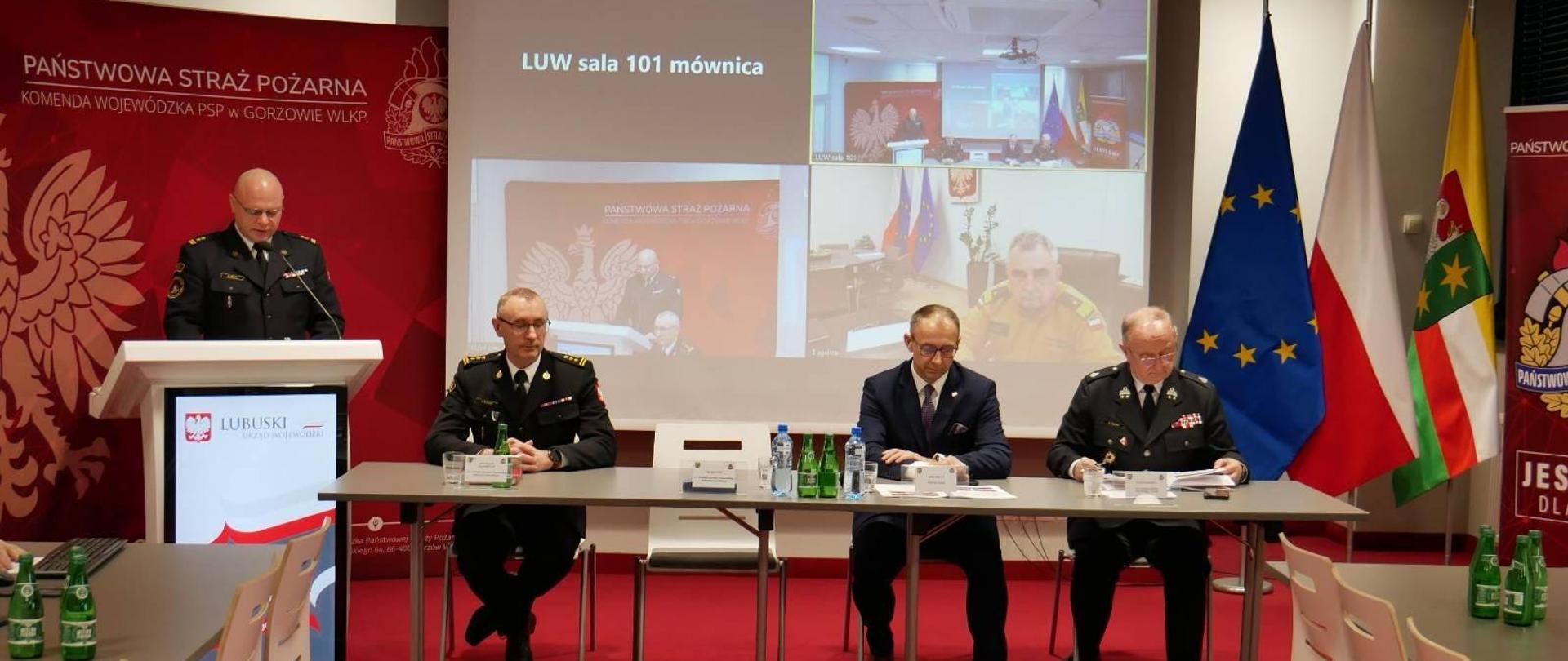 Przedstawiciele województwa lubuskiego przy stole konferencyjnym, w tle łączenie wideo
