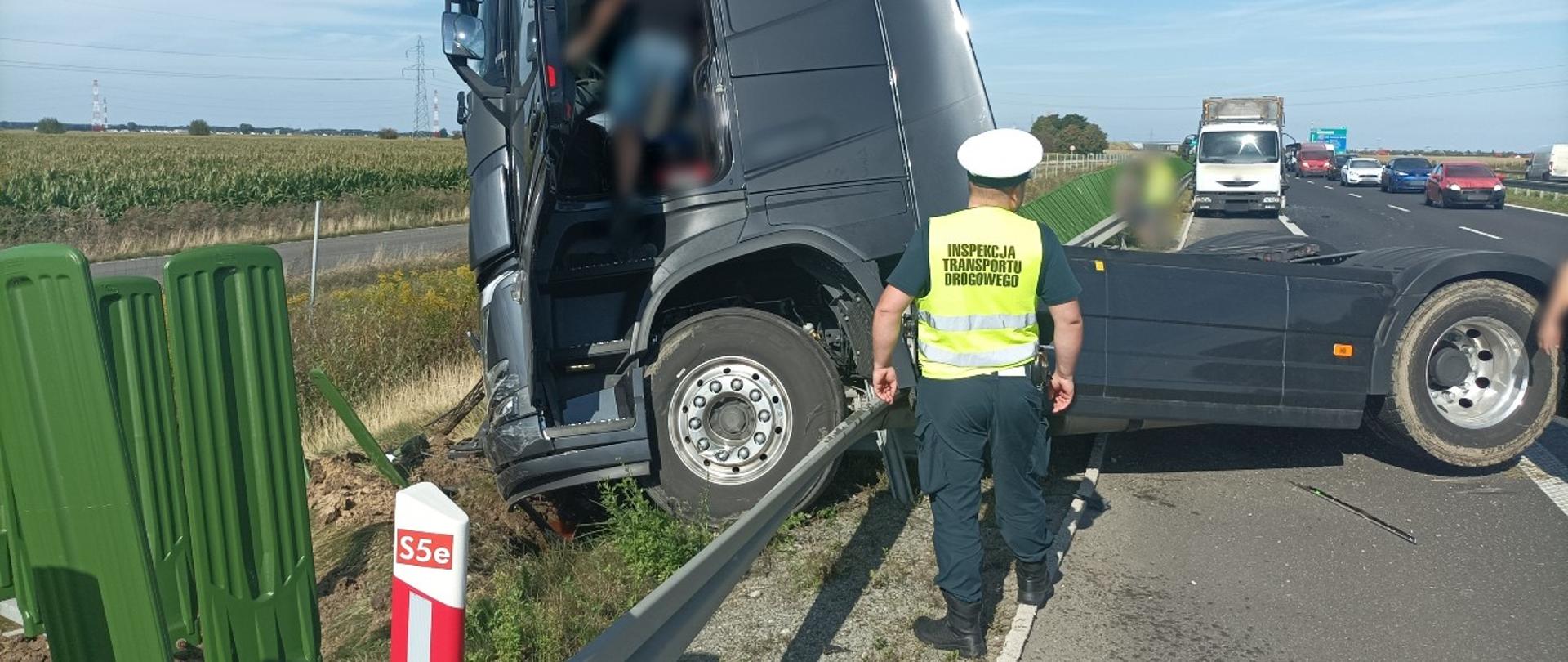 Inspektorzy z Głównego Inspektoratu Transportu Drogowego na miejscu wypadku koło Poznania. Ciągnik siodłowy uderzył w tył ciężarówki-lawety stojącej na pasie awaryjnym.
