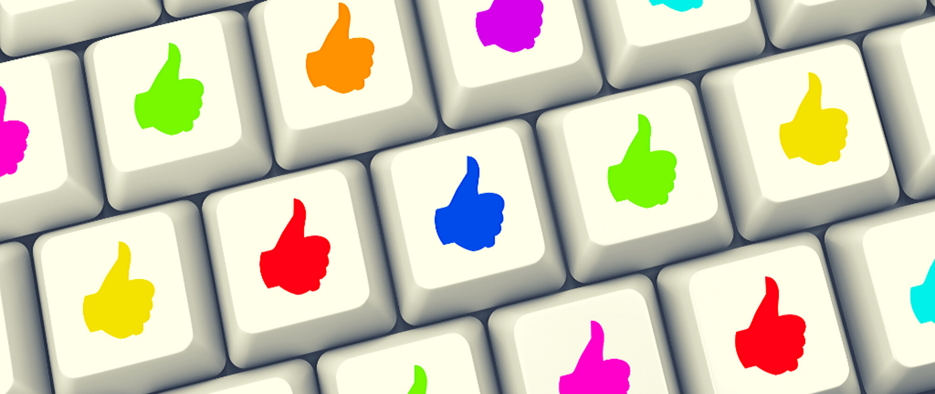 Grafika. Klawiatura komputera z kolorowymi dłońmi z wystawionym kciukiem.