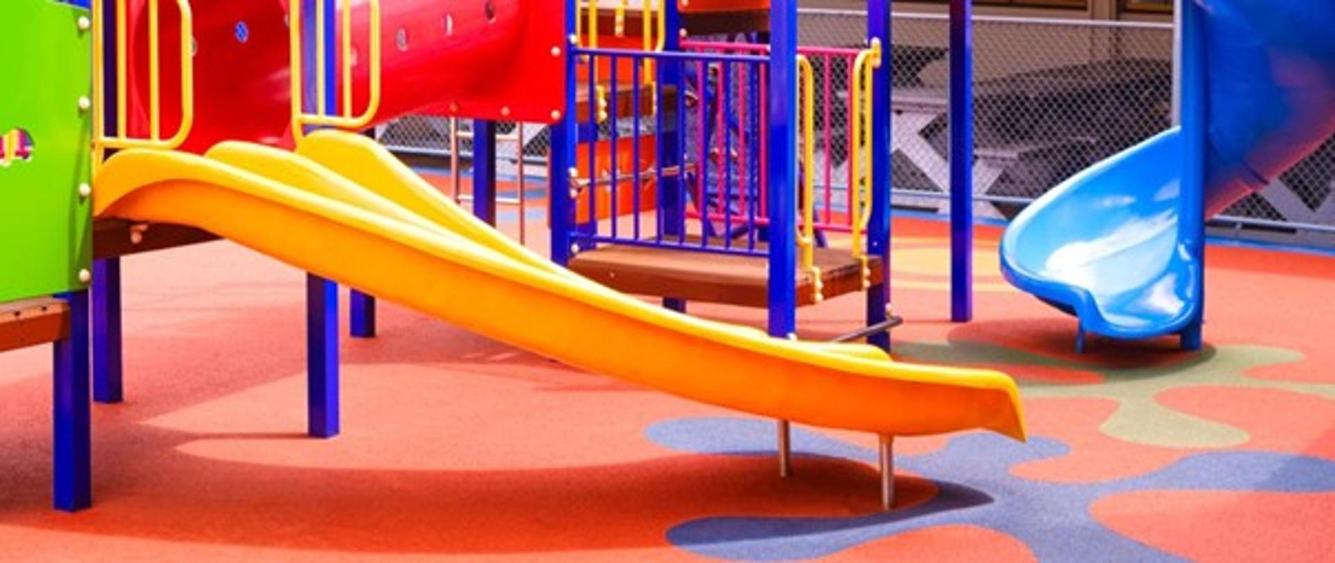 Zdjęcie przedstawia plac zabaw, kilka zjeżdżalni.