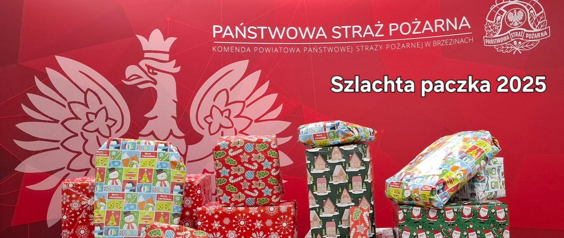 Na tle ścianki komendy paczki ułożone na stole przygotowane do przekazania w ramach ogólnopolskiego projektu „Szlachetna Paczka”
