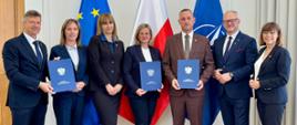 grupa oficjeli pozuje do zdjęcia z podpisaną umową