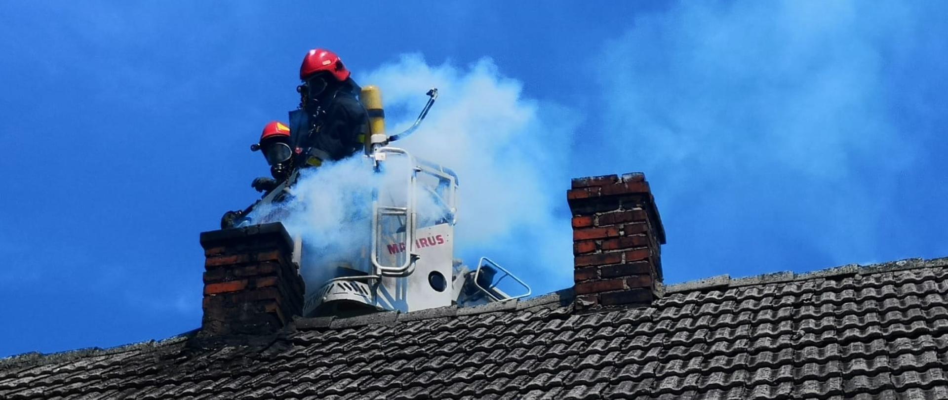 Zdjęcie przedstawia działania strażaków w związku z pożarem sadzy w kominie