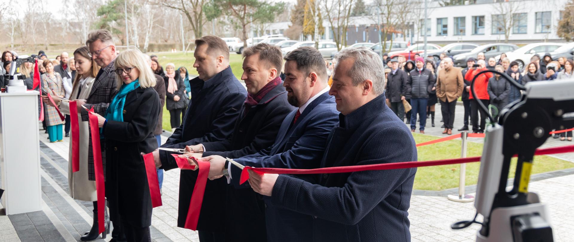 
Grupa ludzi stojąca w sali konferencyjnej

