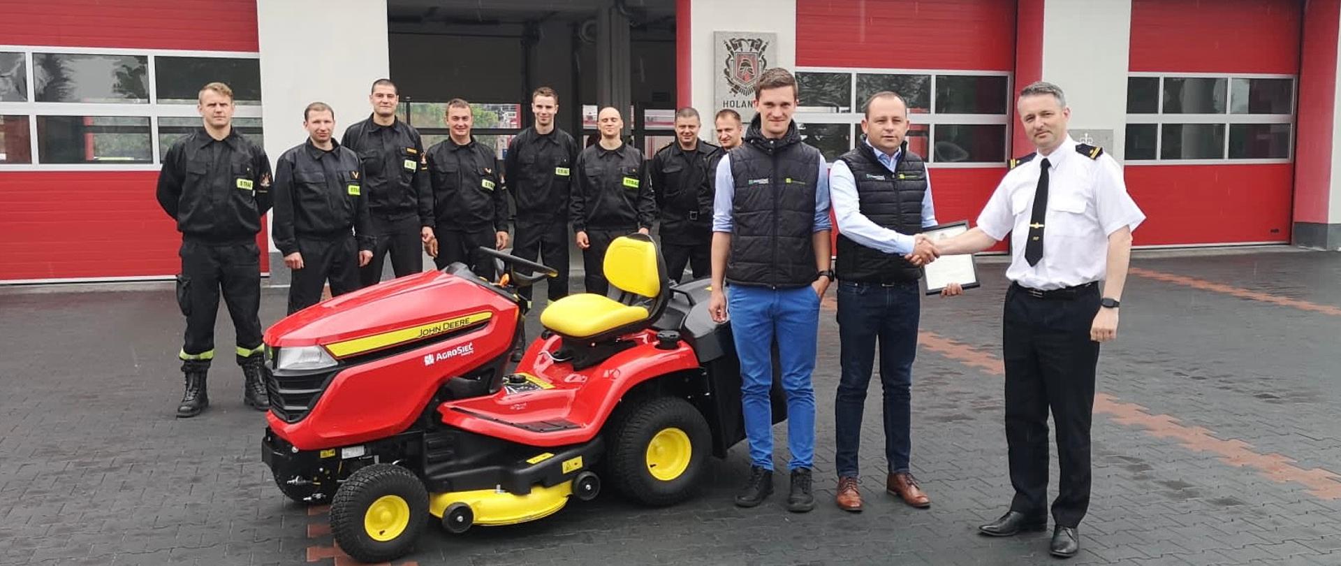 Za zdjęciu znajdują się funkcjonariusze KP PSP w Chełmnie wraz z przedstawicielami firmy Agro-Sieć Maszyny. Zdjęcie wykonano na placu zewnętrznym przed komendą.
