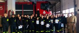 Strażacy z dyplomami w garażu JRG 1