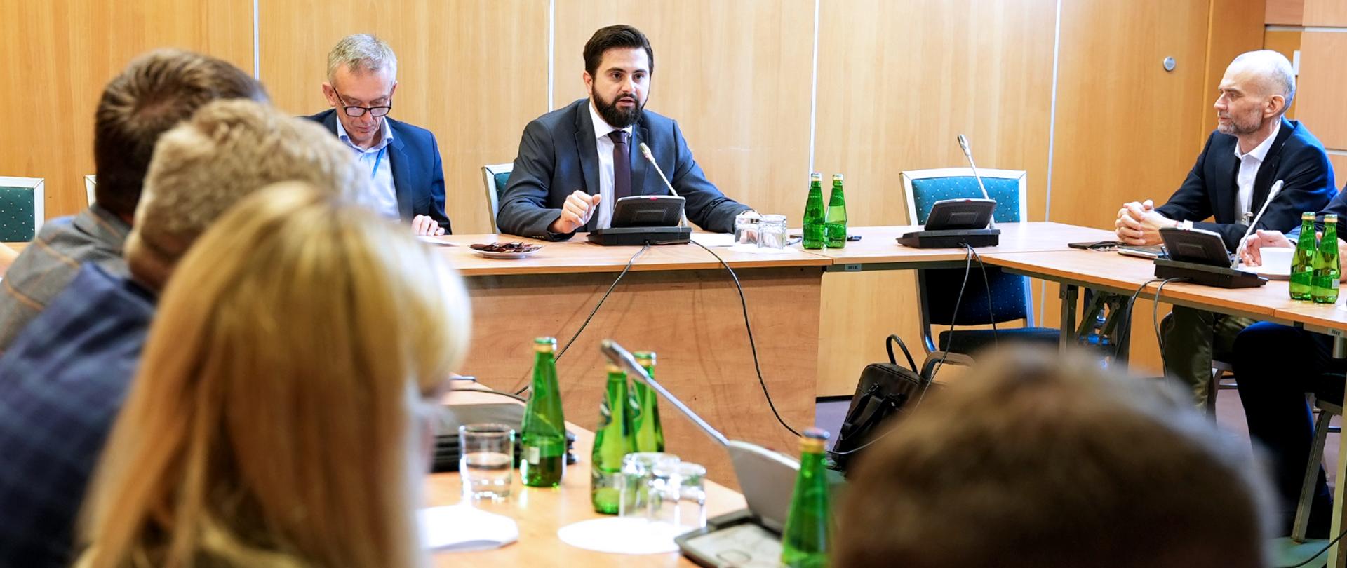 sekretarz stanu Norbert Kaczmarczyk siedzący za stołem prezydialnym