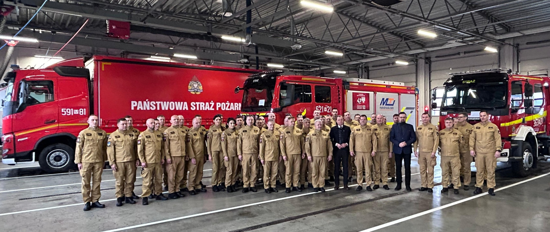 Do zdjęcia pozują wszyscy uczestnicy wydarzenia - strażacy PSP w piaskowych mundurach służbowych z Mazowieckiem Komendantem Wojewódzkim PSP nadbryg. Arturem Gonerą oraz Wojewodą Mazowieckim Mariuszem Frankowskim w garniturze na czele.