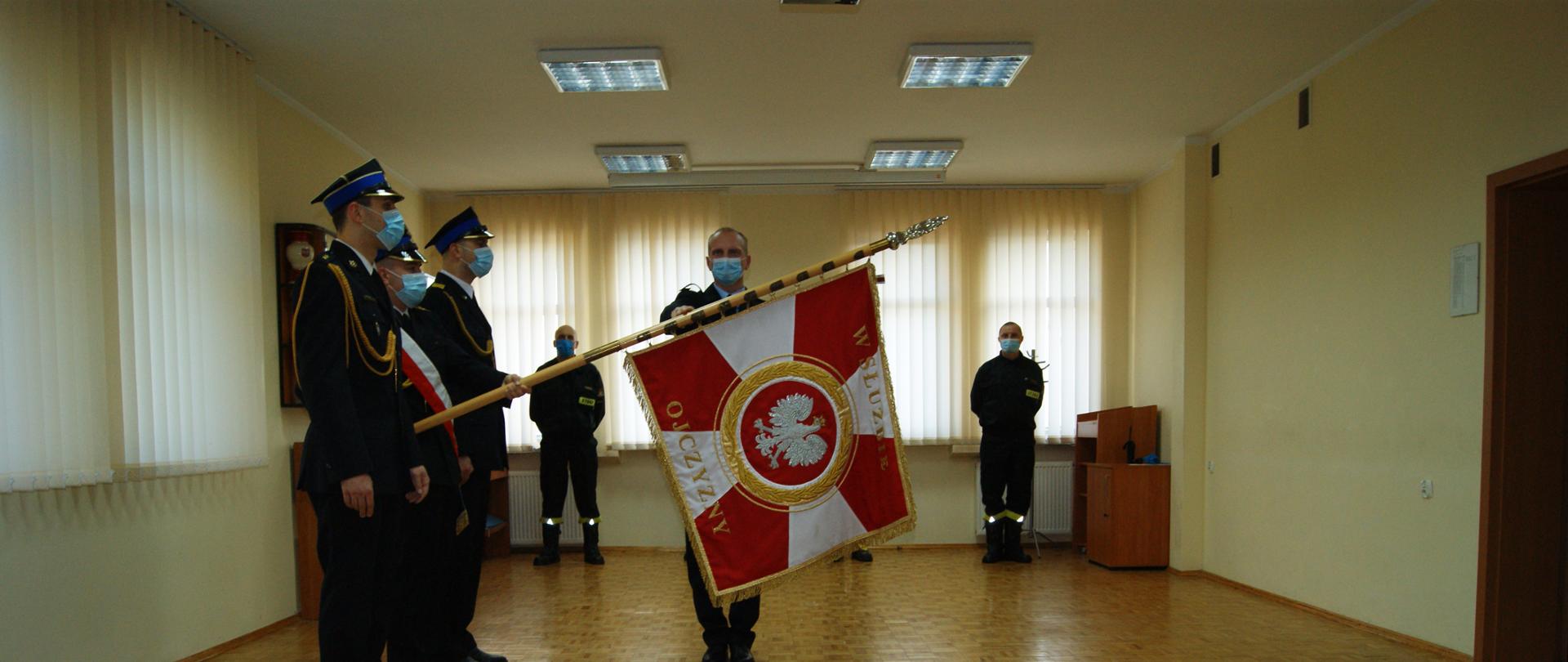 Funkcjonariusz str. Krystian Cichowicz podczas składania roty ślubowania na sztandar KM PSP w Koszalinie, w obecności przełożonych oraz kierownictwa.