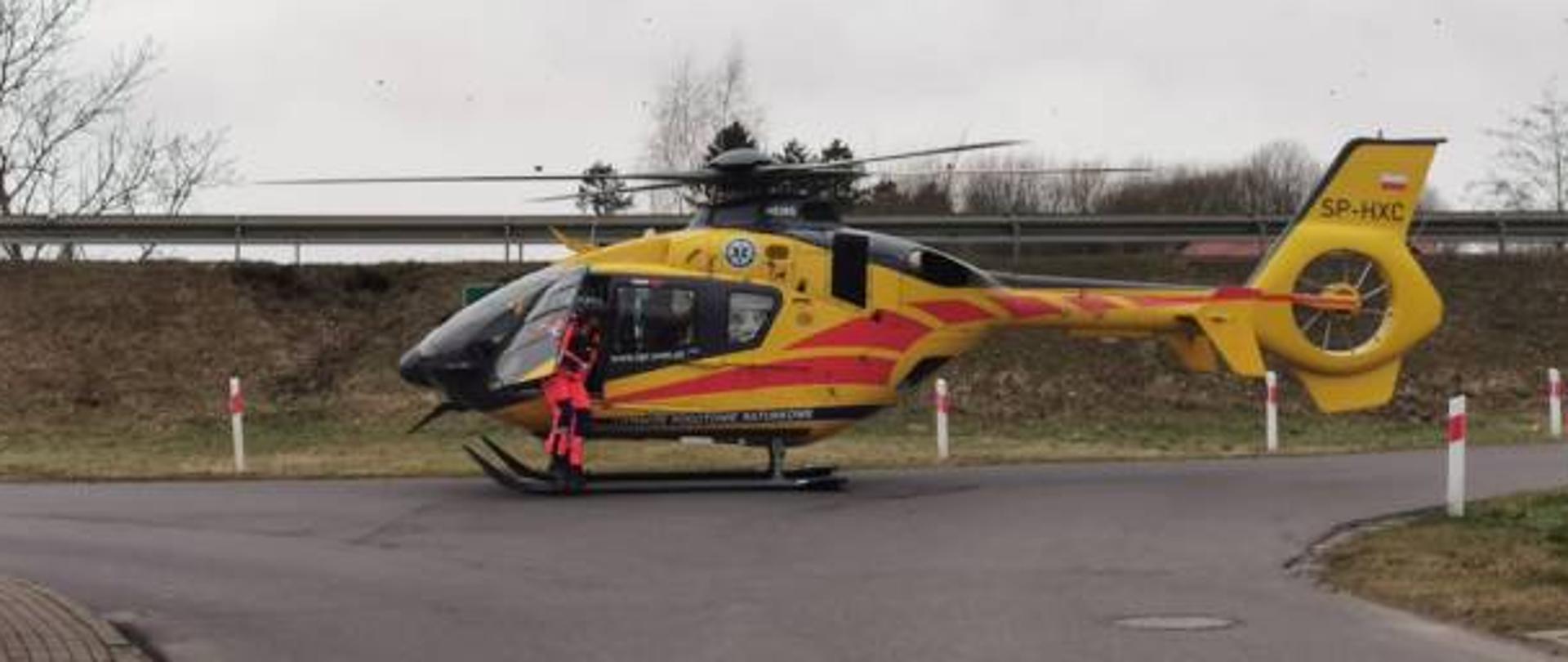 Żółty śmigłowiec stojący na skrzyżowaniu dróg