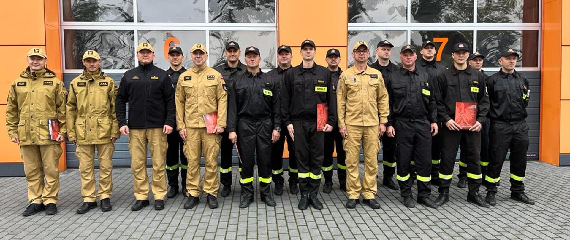 Zdjęcie grupowe strażaków JRG na tle strażnicy.