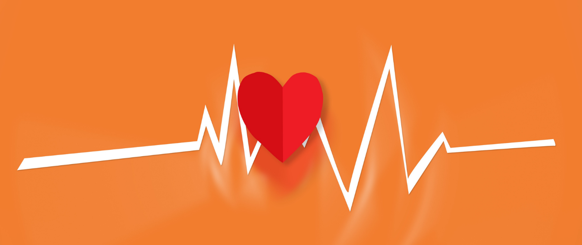 Linia EKG i papierowe czerwone serce na pomarańczowym tle