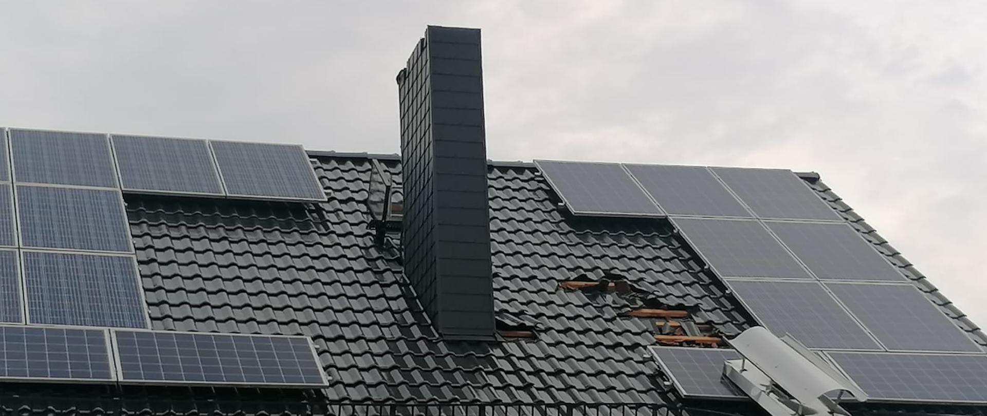 Zrzucone dachówki oraz część komina na budynku mieszkalnym w gminie Strzeleczki w powiecie krapkowickim.
Na dachu panele fotowoltaiczne. Dachówki ceramiczne koloru grafitowego.