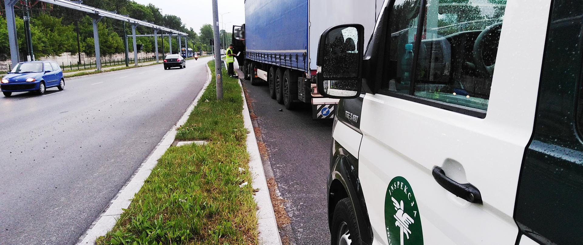 Zespół pojazdów zatrzymany przez inspektorów małopolskiej ITD. Na pierwszym planie inspekcyjny furgon, przed nim zespół pojazdów kontrolowany przez inspektora ITD. Po lewej jadące obok samochody osobowe.