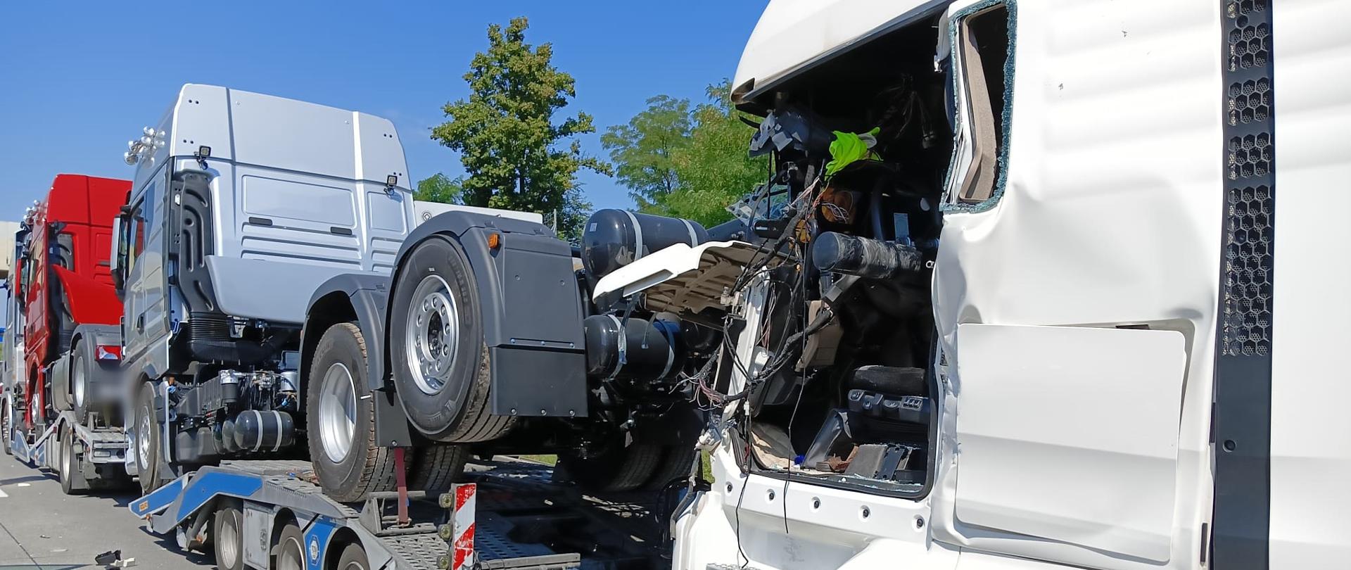 Obraz przedstawia zniszczony samochód ciężarowy po najechaniu na tył pojazdu stojącego w korku.