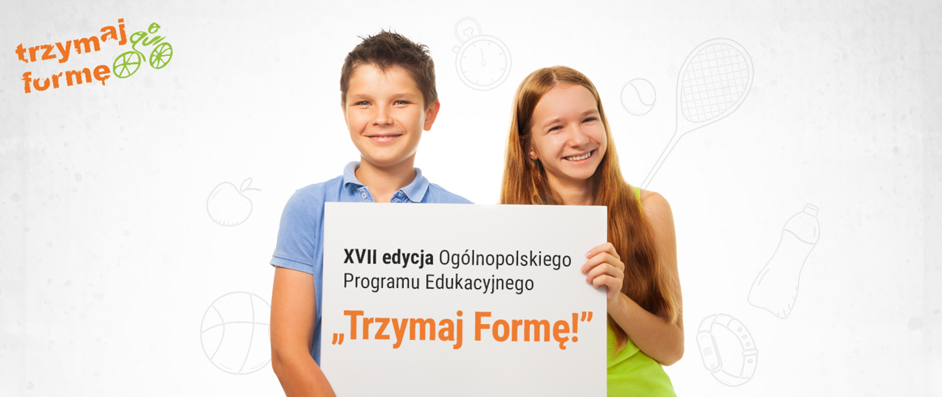Dziewczynka i chłopiec, uśmiechnięci trzymają baner z napisem ,,XVII edycja Ogólnopolskiego Programu Edukacyjnego Trzymaj Formę!"