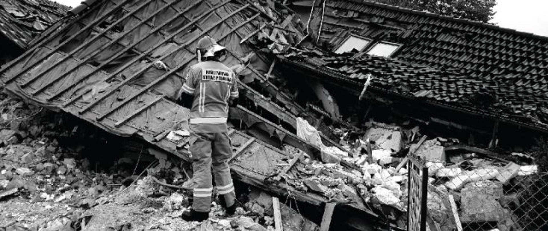 Plakat promocyjny akcji "Pomoc dla Grzegorza". Główna grafika przedstawia postać strażaka stojącego na gruzach budynku. Poniżej znajduje się opis szczegółów akcji.