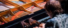 Zdjęcie przedstawia grającego artystę na fortepianie Fazzioli