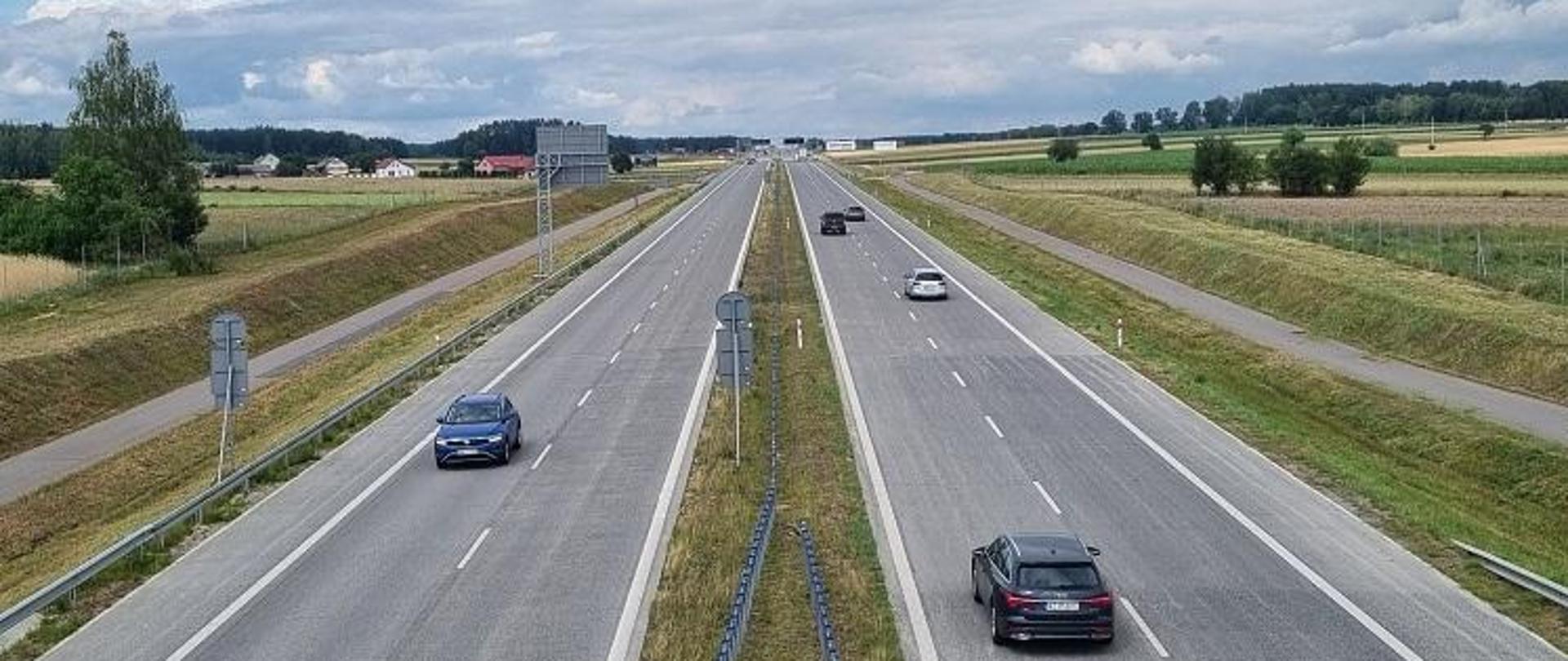 Dwie jezdnie drogi ekspresowej, na nich pojazdy 