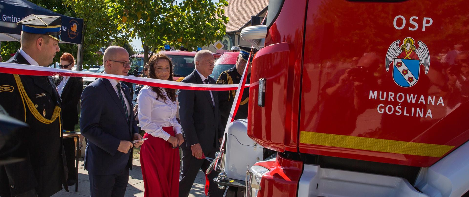 Zaproszeni goście przecinają biało-czerwoną wstęgę
