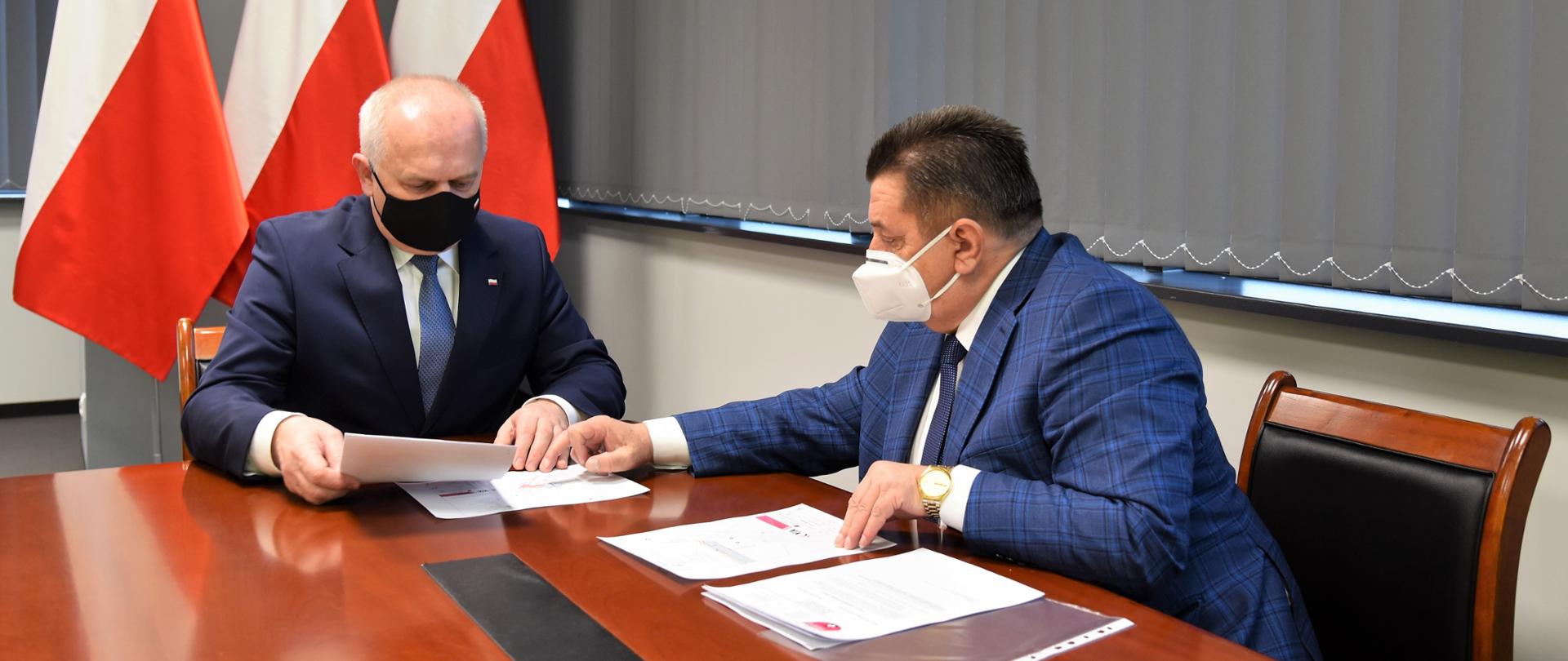 Wojewoda z Wójtem Słońska dyskutują w gabinecie przeglądając dokumenty.