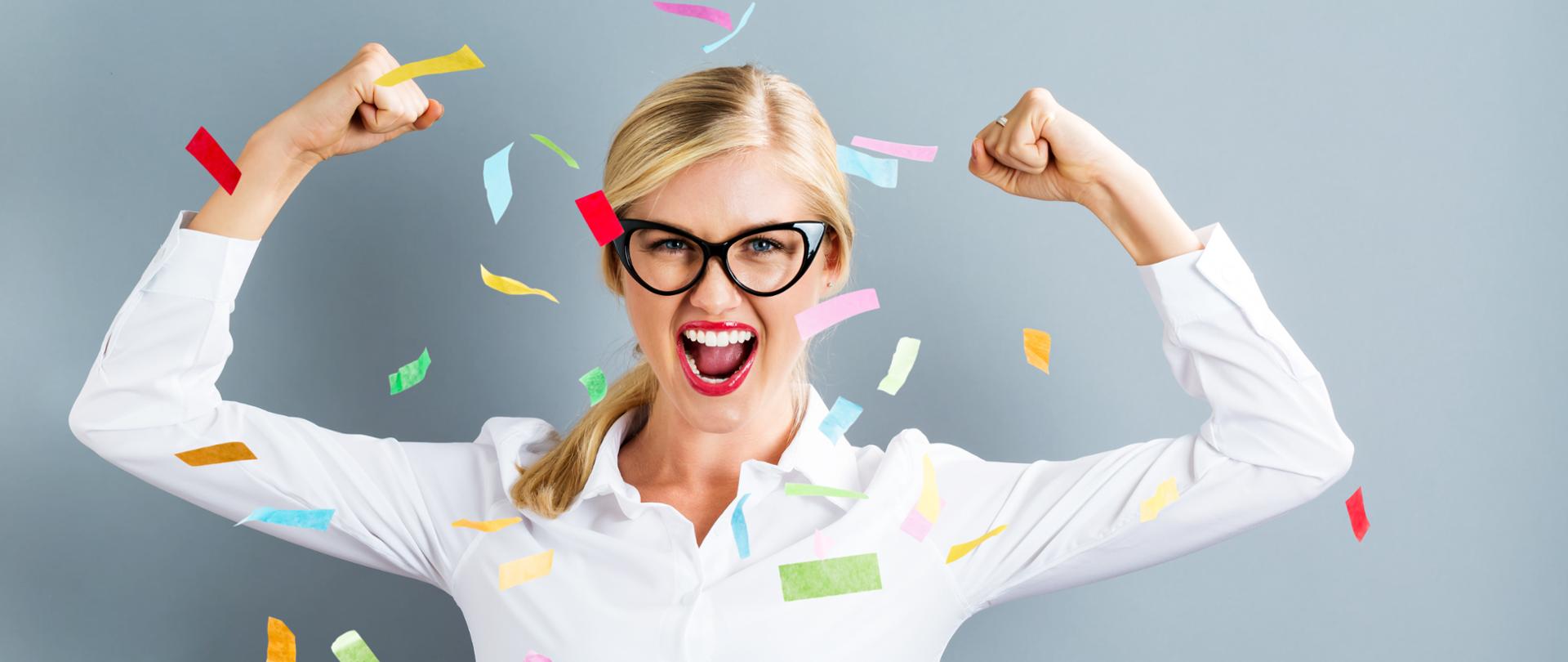 Young strong business woman celebrating with confetti