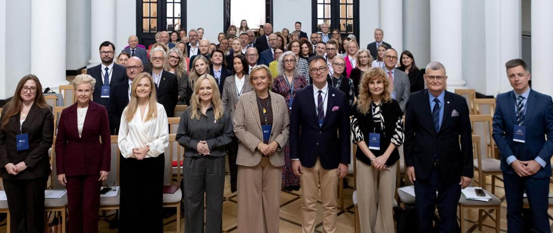uczestnicy spotkania na sali konferencyjnej w postawie stojącej