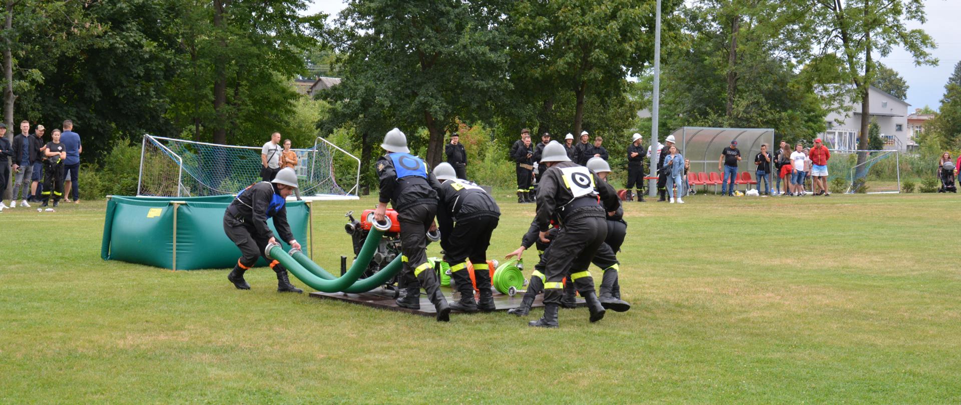 Zdjęcie przedstawia drużynę OSP podczas ćwiczenia bojowego.