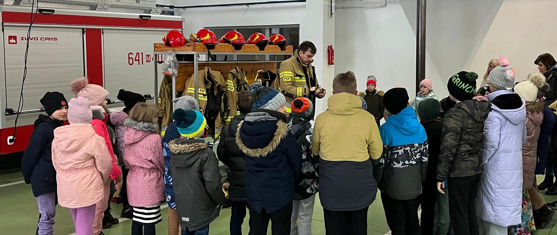 Grupa dzieci poznaje ubiór strażaka