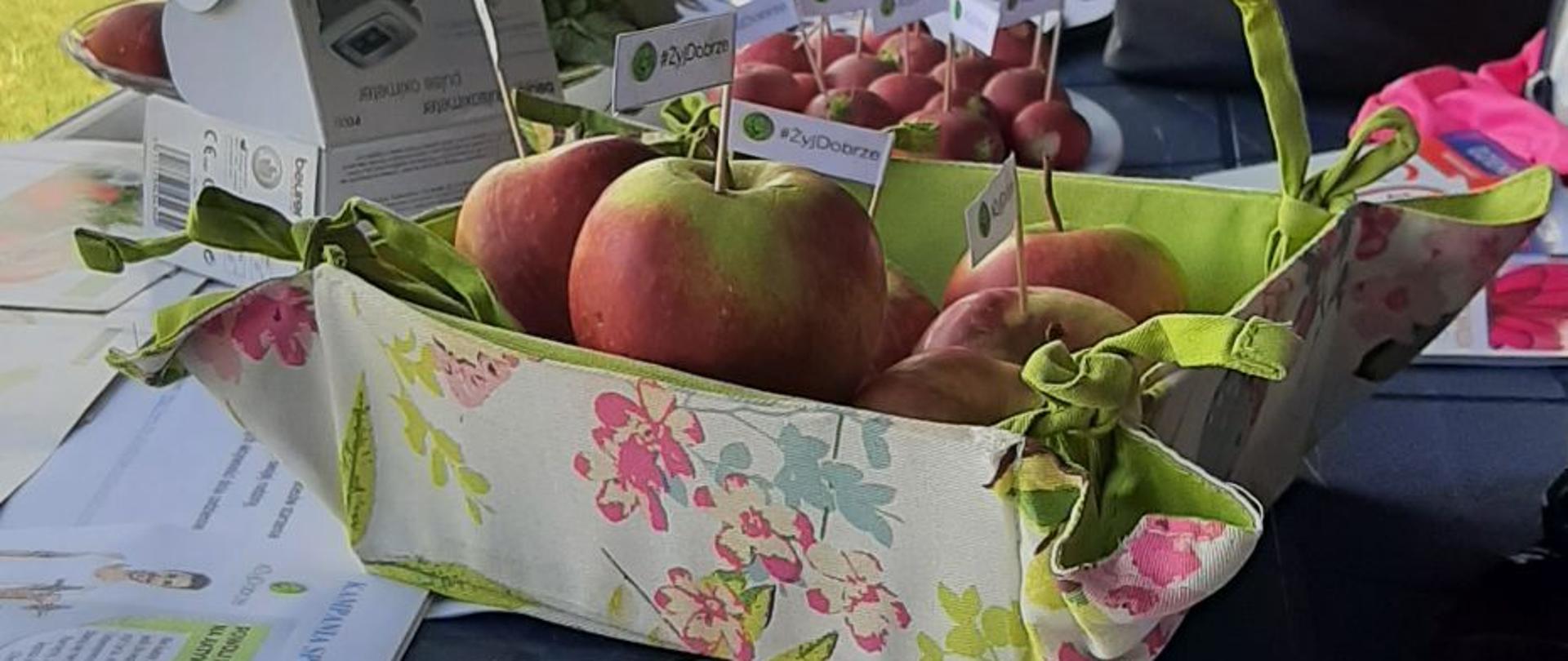 zdjęcie z koszykiem jabłek i ulotkami kampanii żyj dobrze 