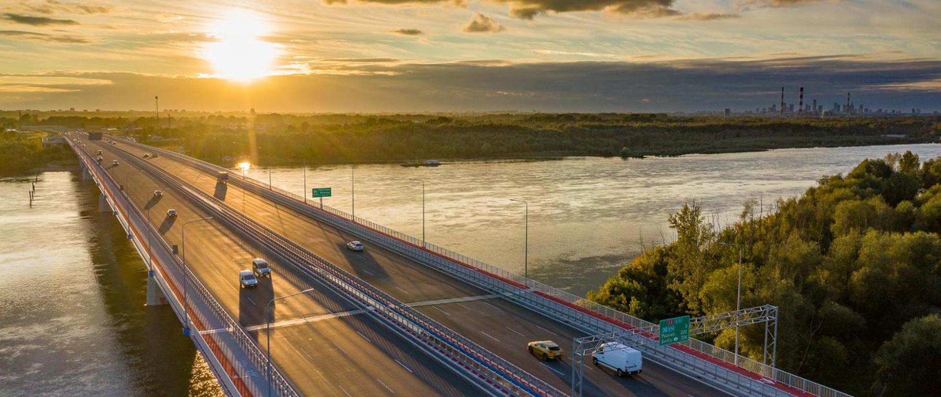 Most na drodze ekspresowej S2 w Warszawie, w oddali miasto, w perspektywie zachód słońca