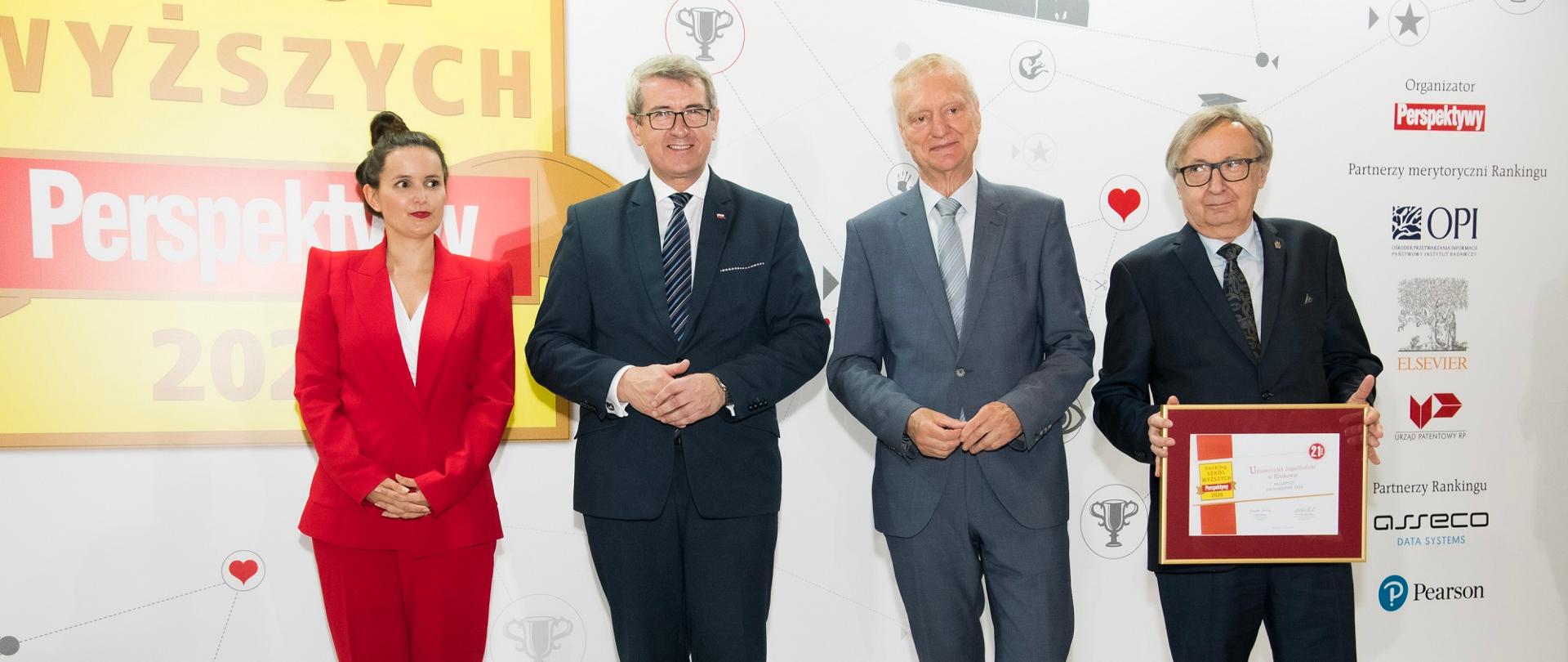 Minister stoi w otoczeniu uczestników gali.