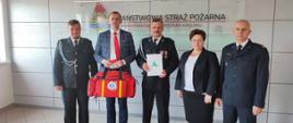 Druhowie podczas przekazania torby medycznej przez wicestarostę oraz komendanta powiatowego psp