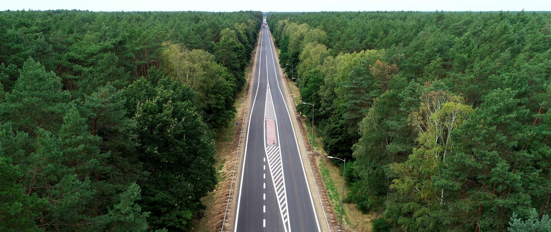 Droga jednojezdniowa w otoczeniu lasów. Zdjęcia z lotu ptaka.