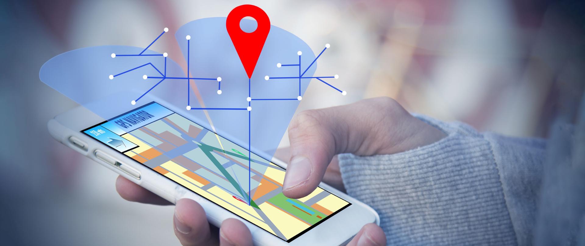 Dłoń trzymająca telefon z oznaczeniami GPS