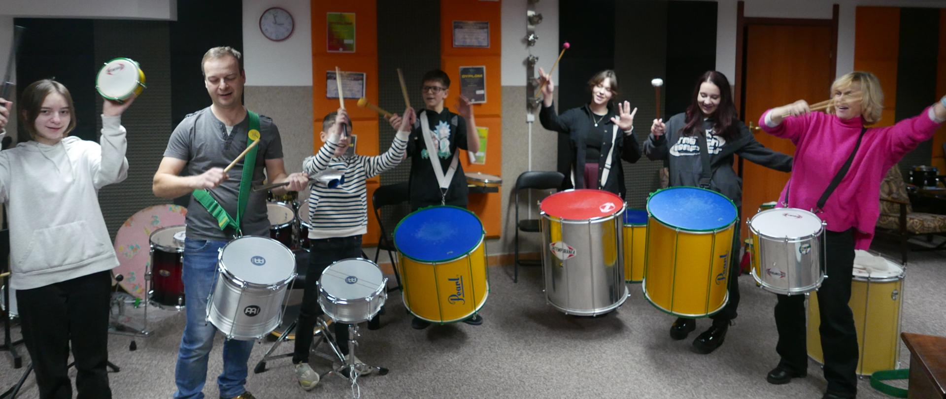  Warsztaty perkusyjne z batucady, pod kierunkiem p.Adama Krzyczkowskiego .Widać że uczestnicy warsztatów dobrze się bawią - wszyscy mają uśmiechnięte twarze.