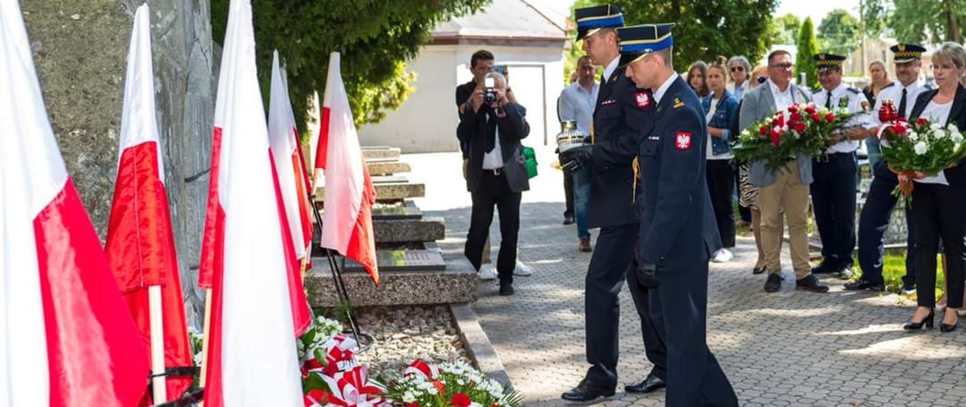 Zdjęcie przedstawia Komendanta Powiatowego PSP w Zgierzu oraz p.o. Zastępcy Komendanta Powiatowego PSP w Zgierzu składających kwiaty po pomnikiem z okazji 83 rocznicy wybuchu II Wojny Światowej.