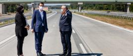 Małgorzata Jarosińska-Jedynak, premier Mateusz Morawiecki, minister Andrzej Adamczyk stoją na drodze.