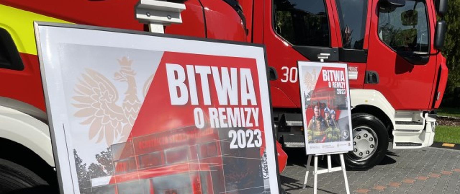 Plakat "BITWA O REMIZY" 2023, w tle samochody gaśnicze