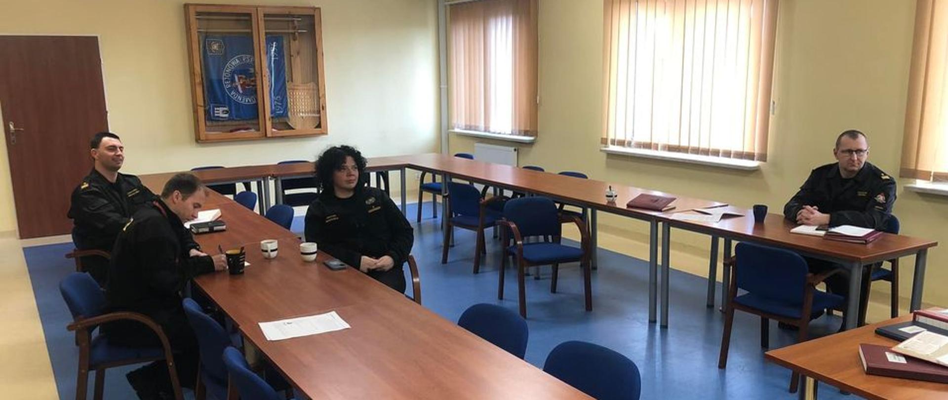 Na zdjęciu znajdują się funkcjonariusze na sali wykładowej w czasie trwania zajęć online dot. prewencji społecznej. 