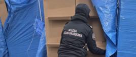 Funkcjonariuszka Służby Celno-Skarbowej przy kartonach.