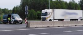 Od lewej strony: kierowcy stojący obok oznakowanego radiowozu ITD typu furgon i ciężarówka zatrzymana do kontroli drogowej.