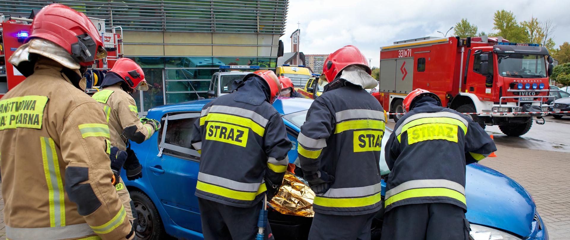 Pokazy ratownictwa technicznego. Strażacy rozcinają konstrukcję pojazdu.