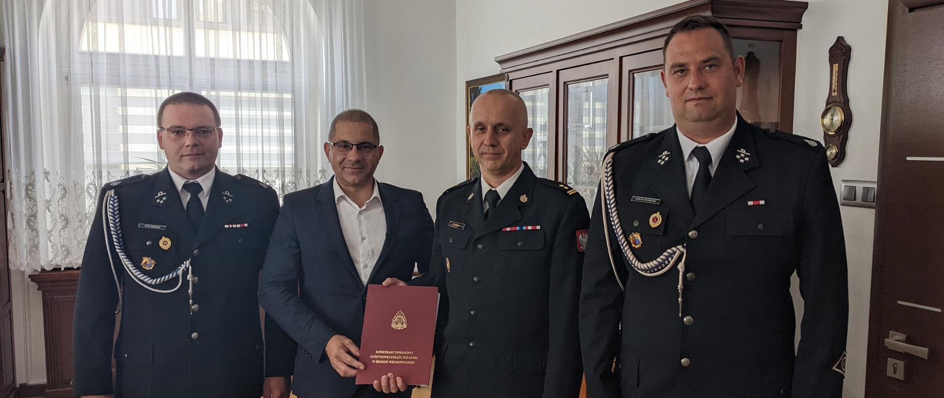 Pamiątkowe zdjęcie w gabinecie Burmistrza Środy Wielkopolskiej po podpisaniu porozumienia trójstronnego w sprawie włączenia jednostki OSP Koszuty do Krajowego Systemu Ratowniczo - Gaśniczego. Stoją od lewej Naczelnik OSP Koszuty dh Piotr Bandosz, Burmistrz Miasta Środa Wielkopolska Pan Piotr Mieloch, Komendant Powiatowy PSP w Środzie Wielkopolskiej bryg. Tomasz Skorlinski oraz Prezes OSP Koszuty dh Marcin Przybylski.