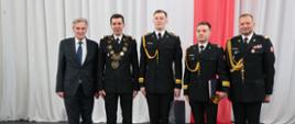 Mężczyzna w ubraniu cywilnym i 4 funkcjonariuszy PSP stoją w rzędzie pozując do zdjęcia