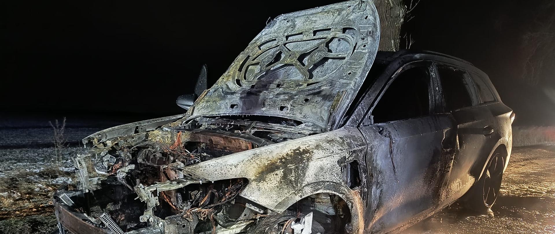 Spalony pojazd na drodze, jest ciemno