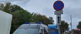 Radiowóz ITD typu bus stoi obok znaku "zakaz zatrzymywania się". Za nim ciężarówka z niebieską kabiną.