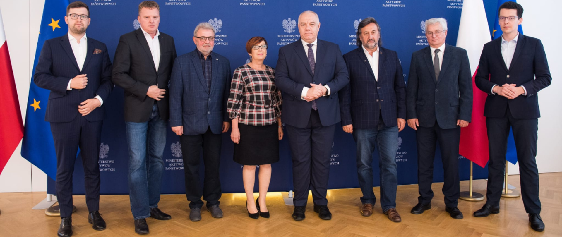 Uczestnicy spotkania pozują do wspólnego zdjęcia na tle ścianki z logotypami MAP i flagami Polski i UE. Na początku rzędu z lewej - wiceminister Andrzej Śliwka, na środku wicepremier Jacek Sasin, z prawej Marcin Izdebski